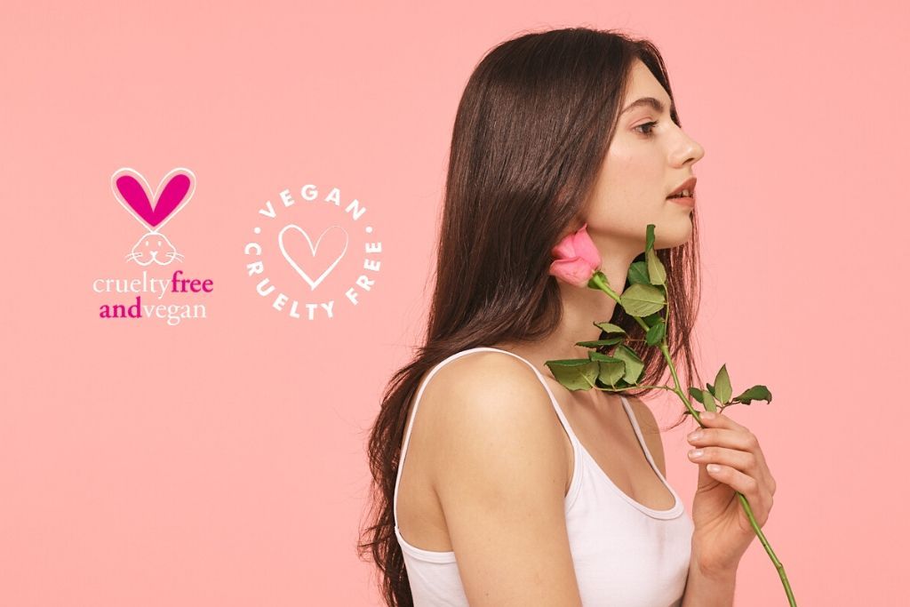 Vegan hair care. Brunette girl holding rose against pink background with cruelty free & vegan kigi,